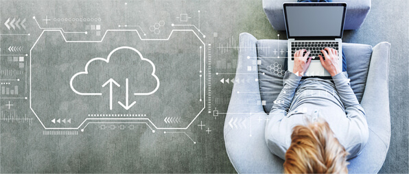 girl sitting down on her laptop finding cloud solutions